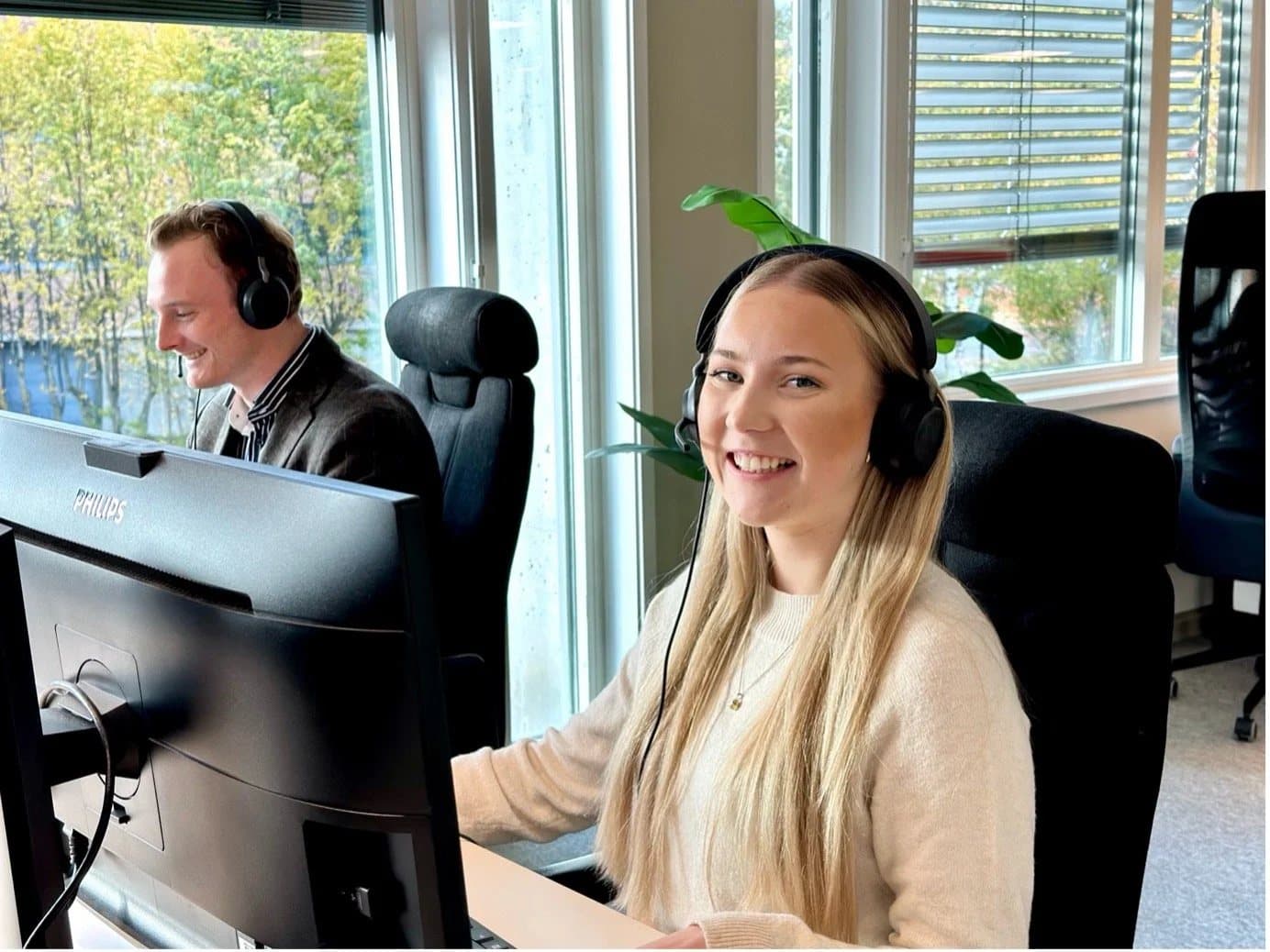 Smilende medarbeidere i kontorlandskapet hos Loyalty