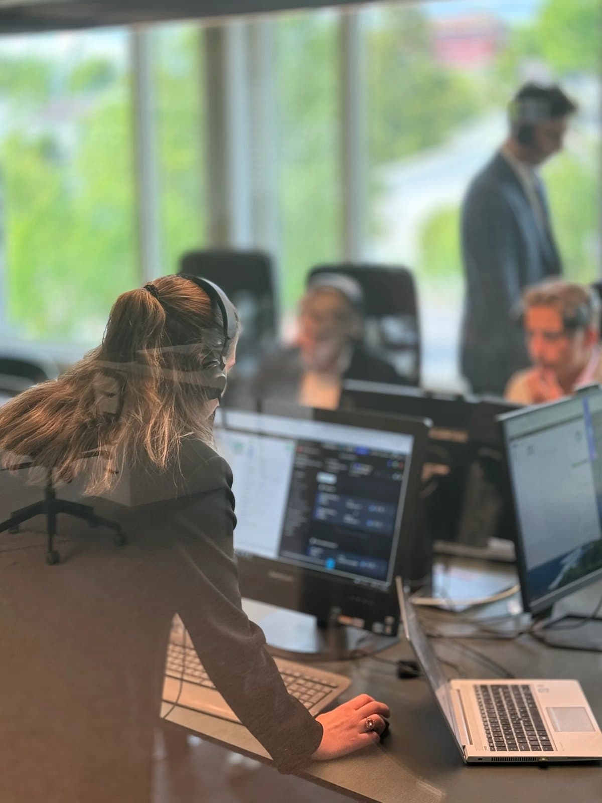 Medarbeider med headset jobber ved skjermen