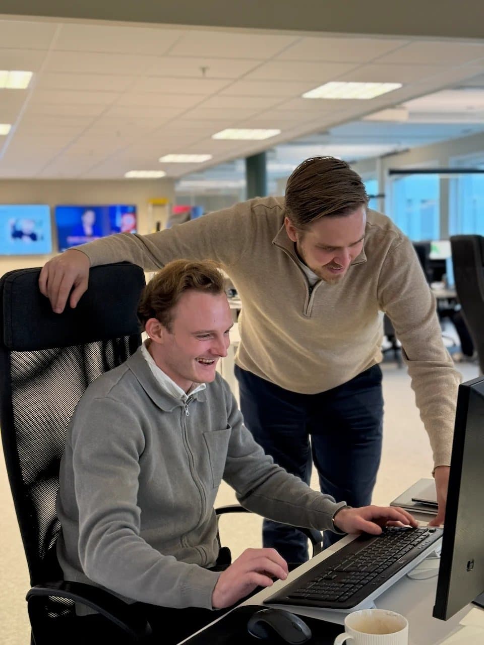 To kolleger hos Loyalty ser på en skjerm sammen og ler